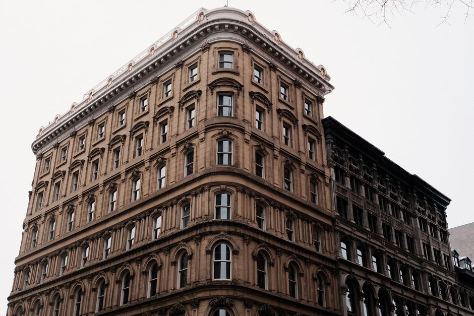 A historic brick building with restoration scaffolding in a downtown setting