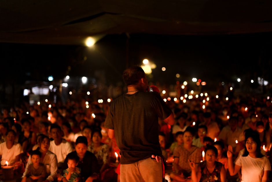 Families gathered with lawn chairs at a downtown park for an evening community vigil