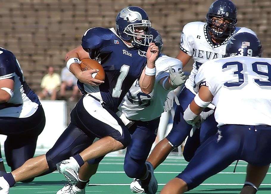 A quarterback carries out a passing play during a football game