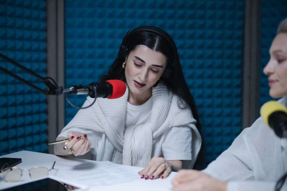Radio hosts recording a morning show together in a broadcast studio