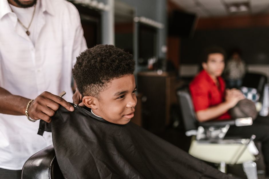 A child getting a haircut at a salon training program