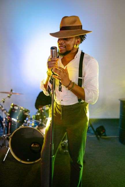 R&B vocalist singing into a microphone under stage lights