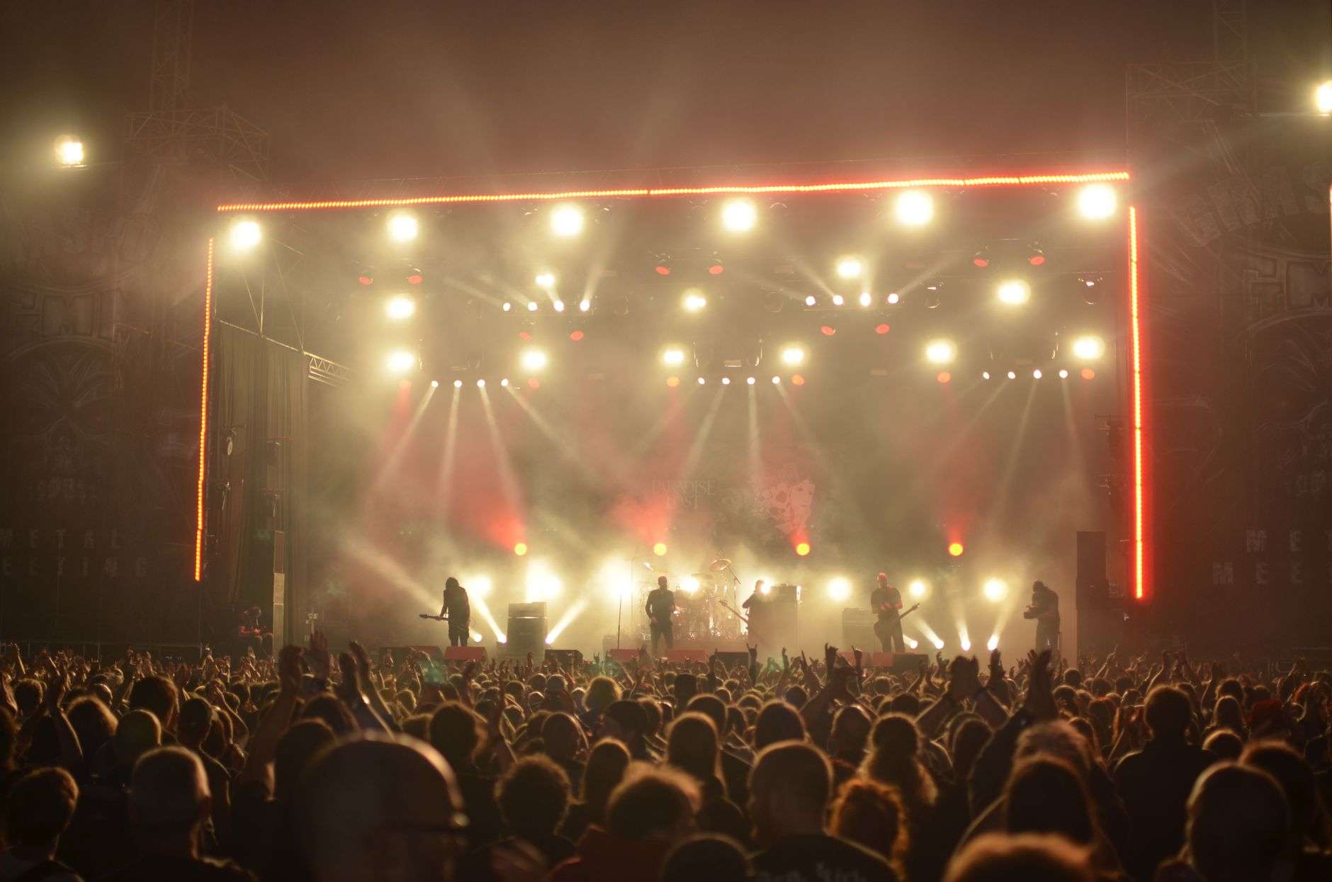 Crowd at a sold-out rock concert with bright stage lighting