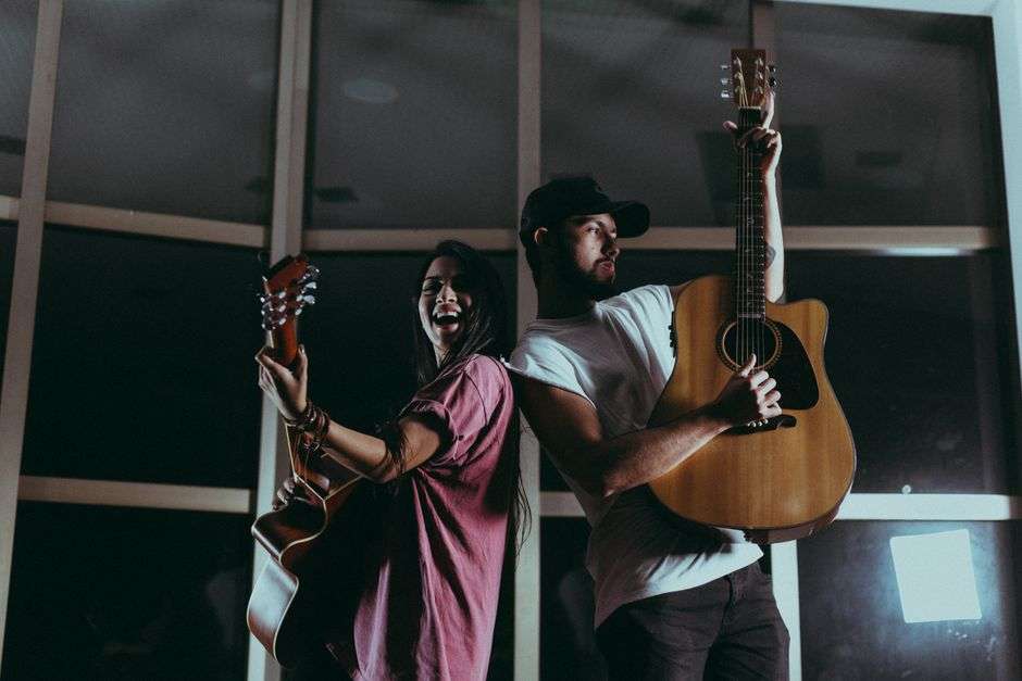 Two acoustic guitarists play together on stage, illustrating the guitar duo sound of Roman Street