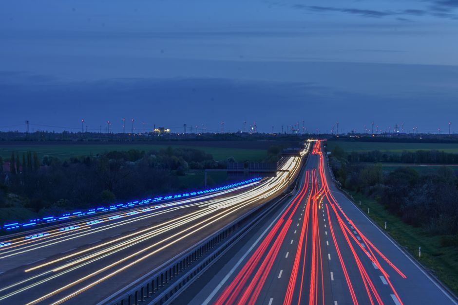 Two-lane highway stretch at dusk with passing traffic
