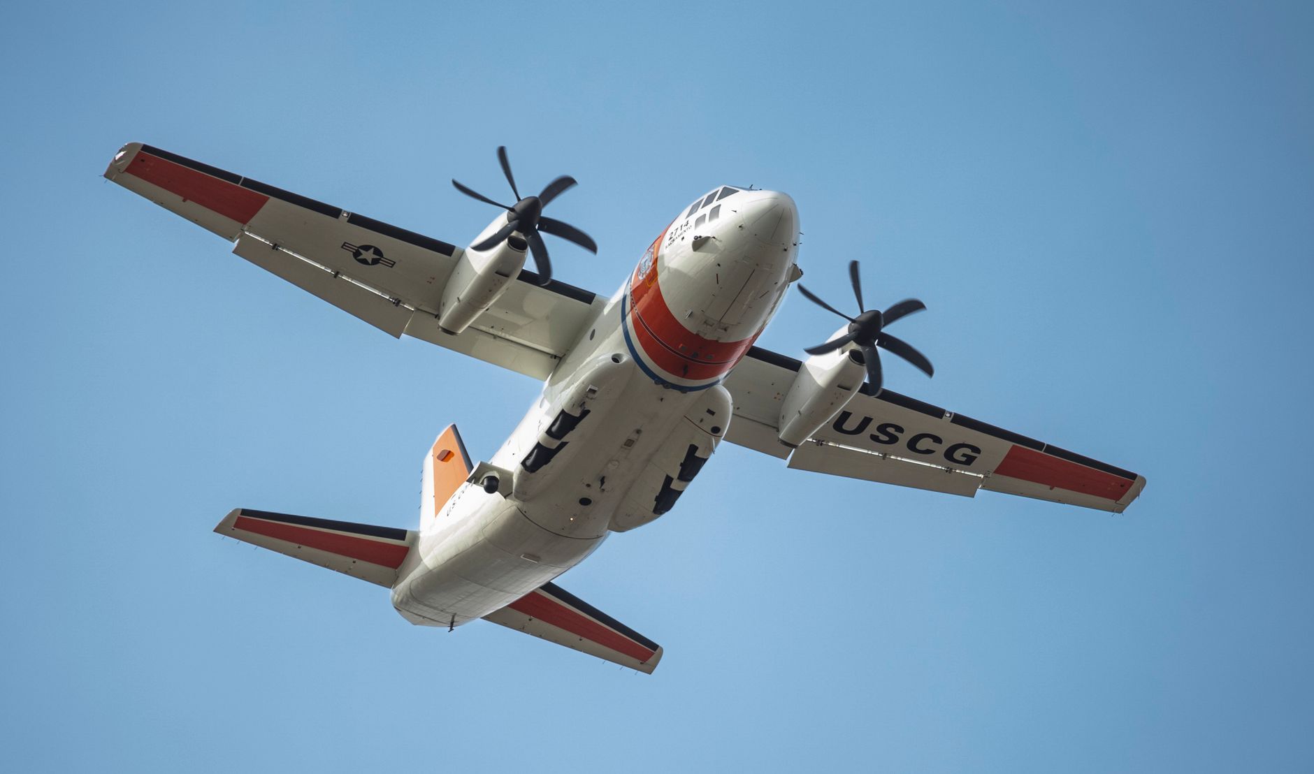 A maritime patrol aircraft flying above a coastline