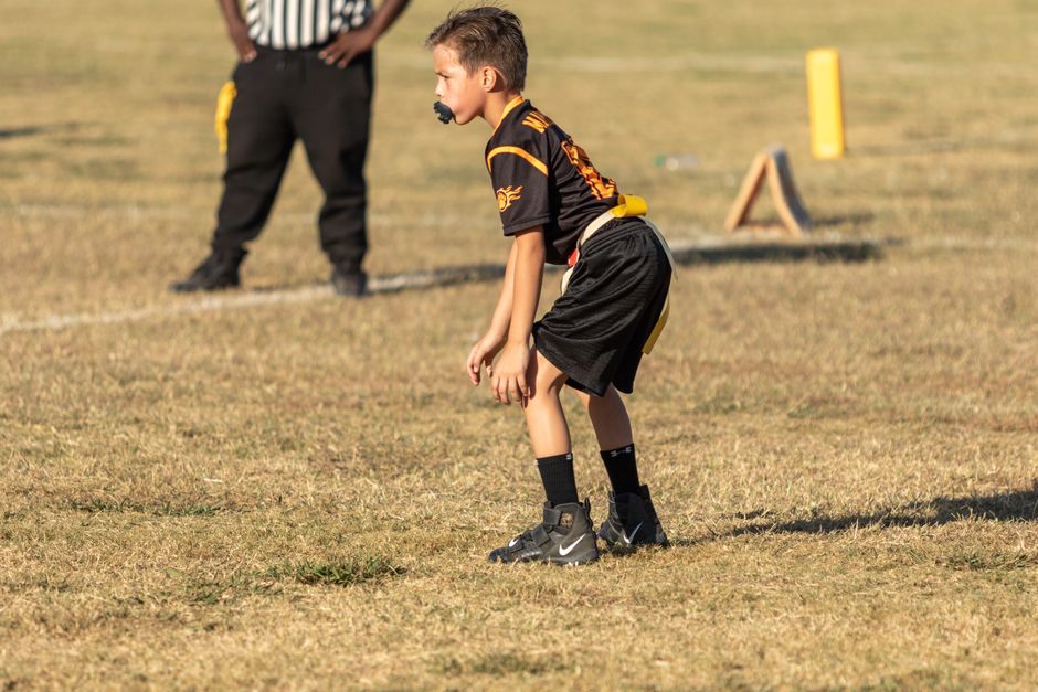 Kids playing youth flag football on a field
