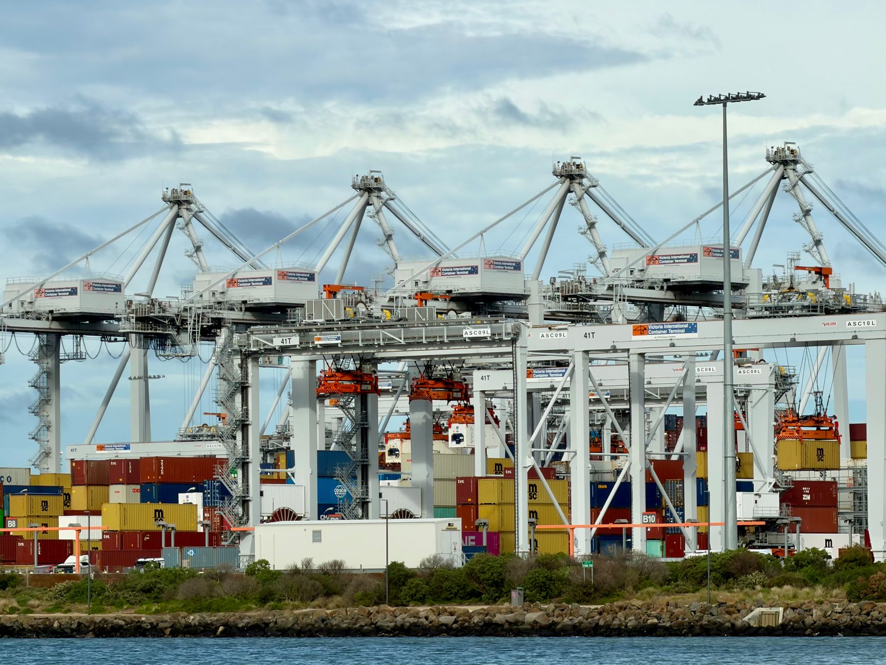 Container cranes and stacked cargo containers at a shipping port