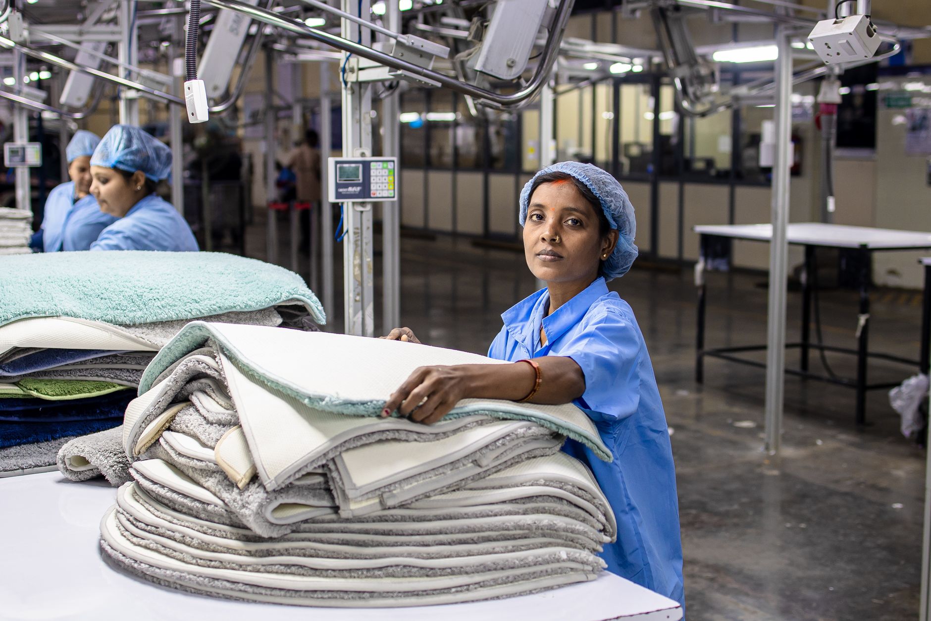Workers at stations along an industrial manufacturing assembly line