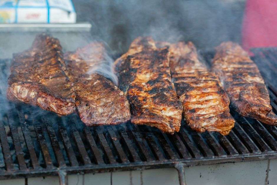 Slow-smoked barbecue ribs cooking on a grill