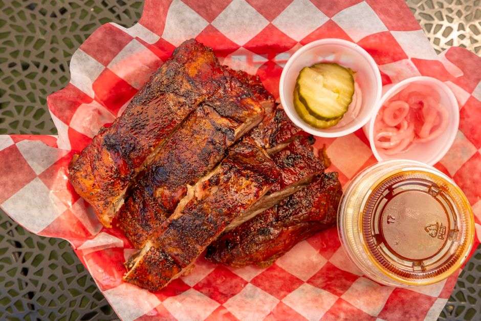 A plate of smoked barbecue ribs with sides at a Southern restaurant