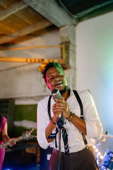 Band performing on stage with vocalist singing into microphone