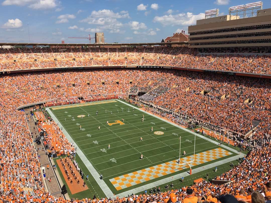 Aerial view of a green college football field inside a stadium