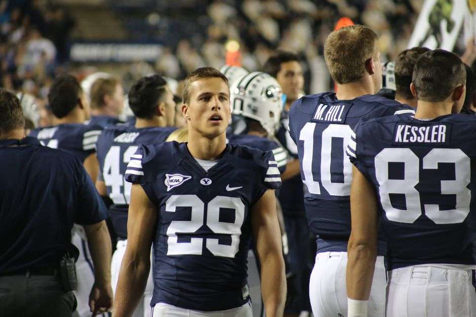 Football players and coaches on the sideline during a college football game