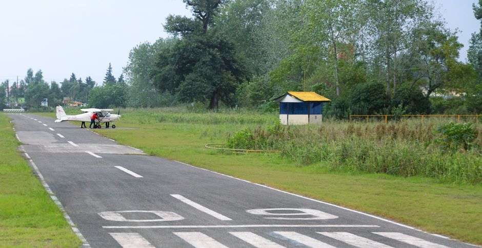 Small single-engine airplane parked on a runway at a general aviation airfield