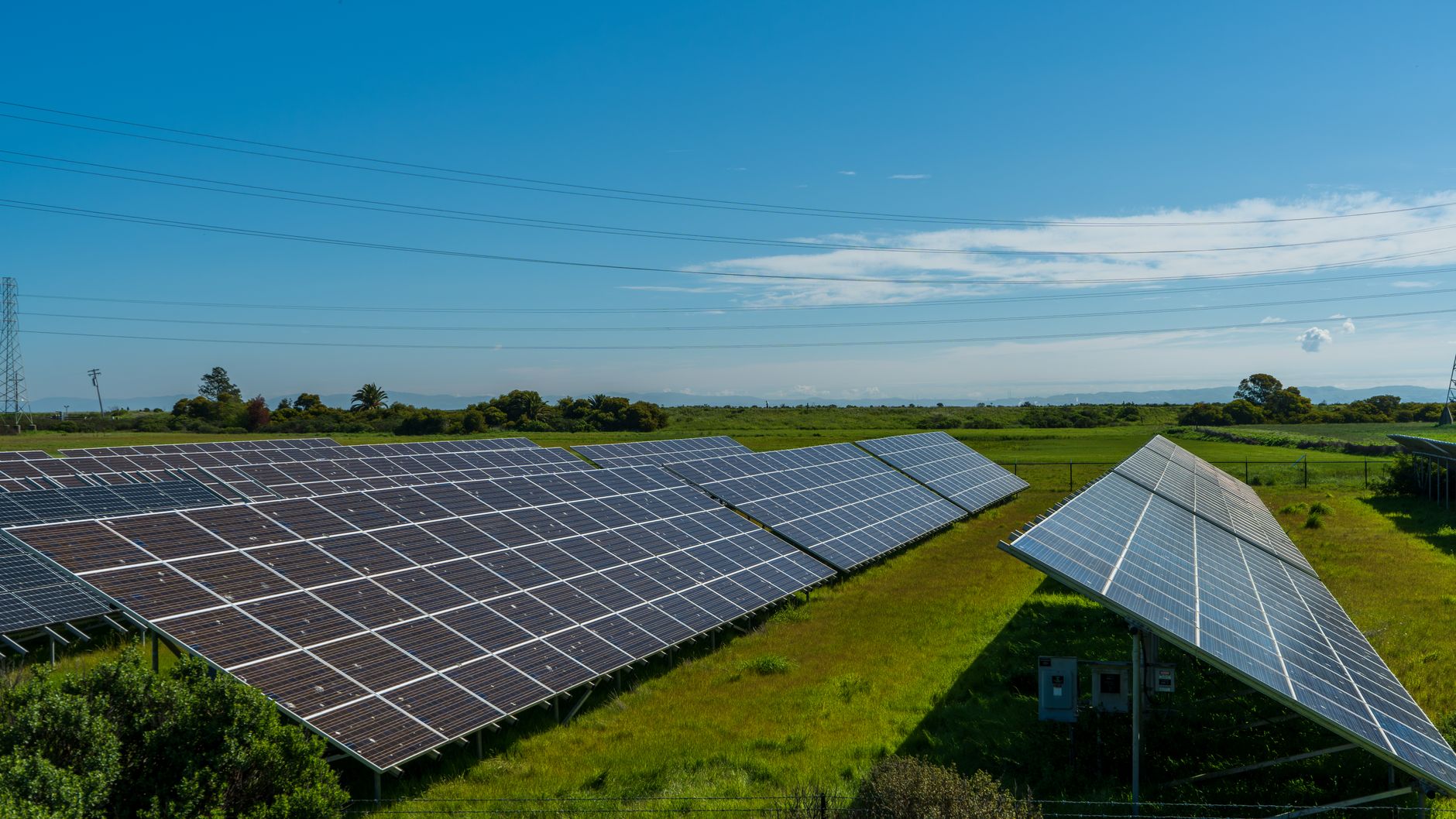 A rural landscape with solar panel arrays installed across open farmland