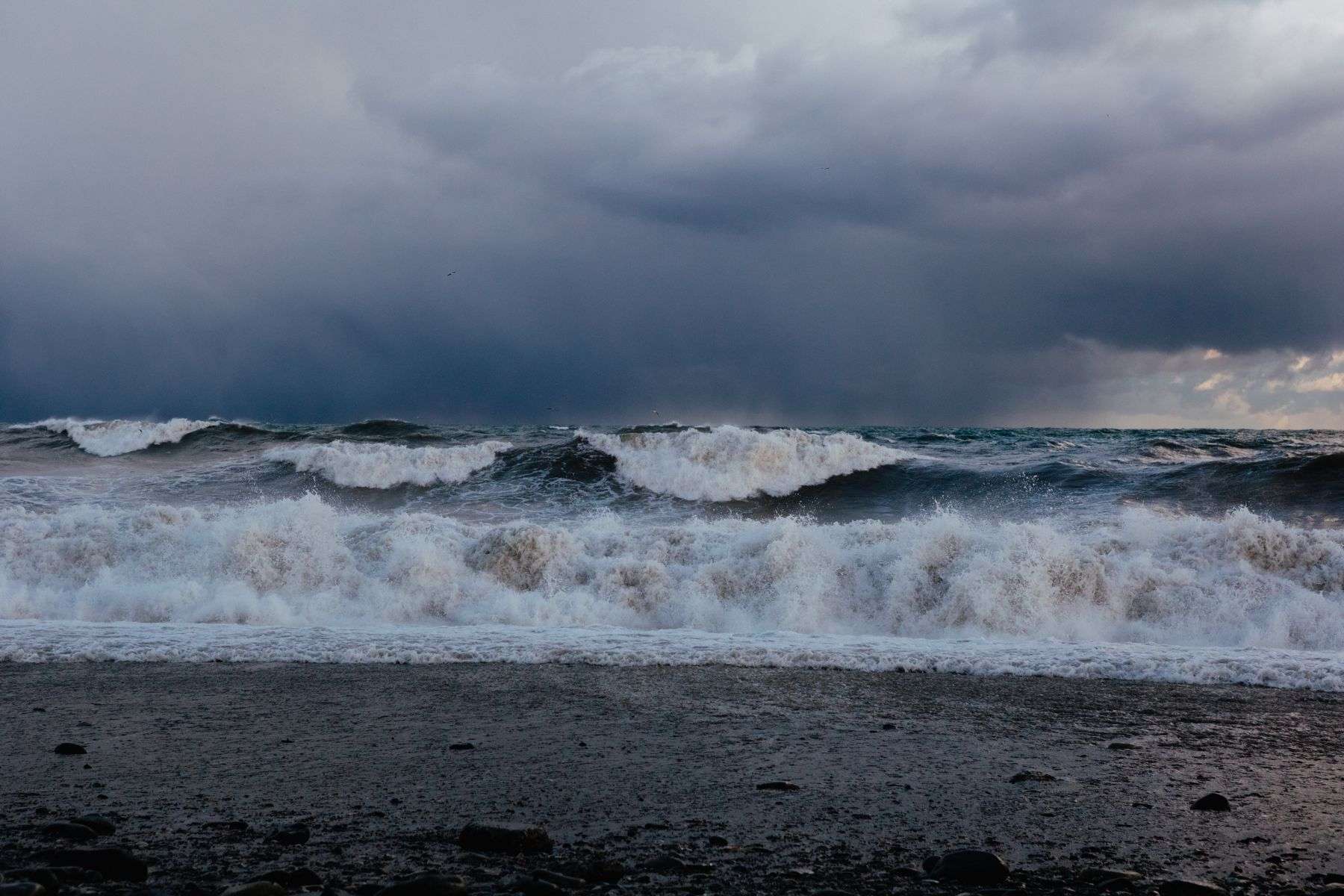 Dark stormy skies over choppy waves crashing along a Gulf Coast shoreline