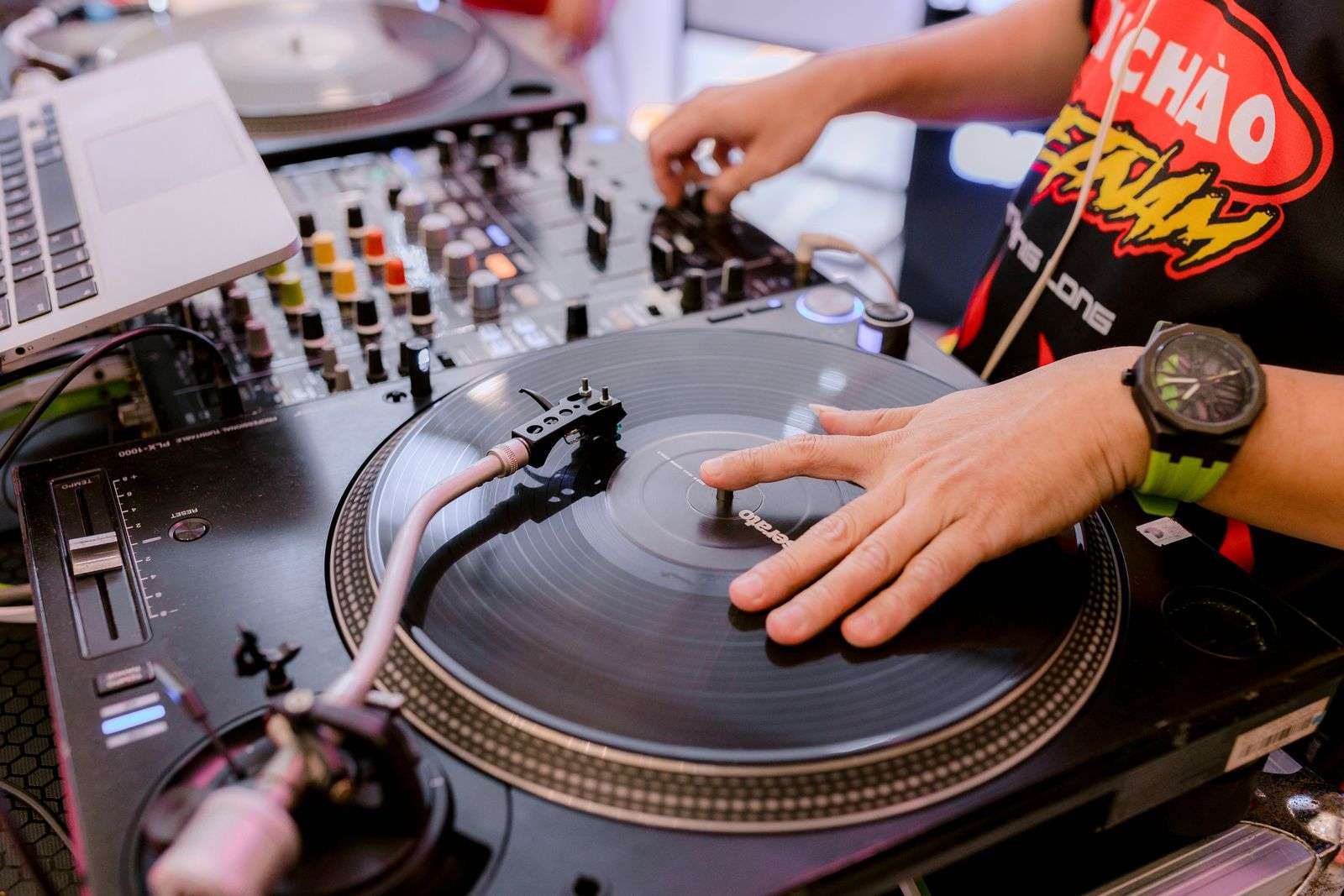 A DJ scratching vinyl records on turntables during a live hip-hop performance