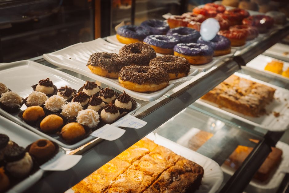 A glass display case filled with fresh doughnuts representative of Sugar Rush Donut Co. in Midtown Mobile
