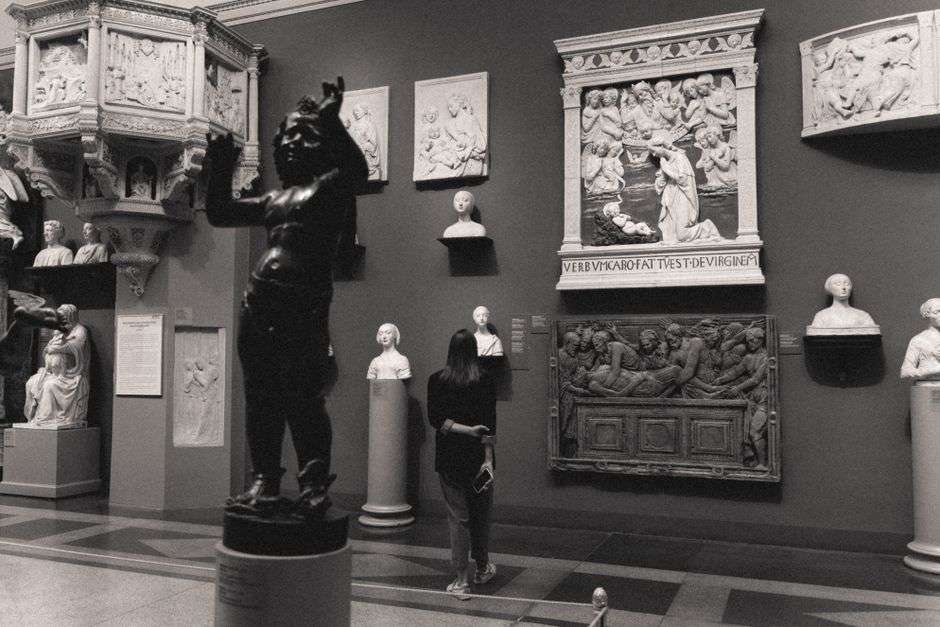 A gallery visitor views whimsical sculptures and artwork on display