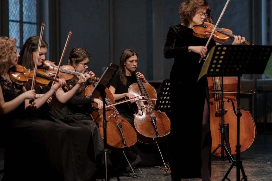 String and piano quartet musicians performing together at a chamber music concert