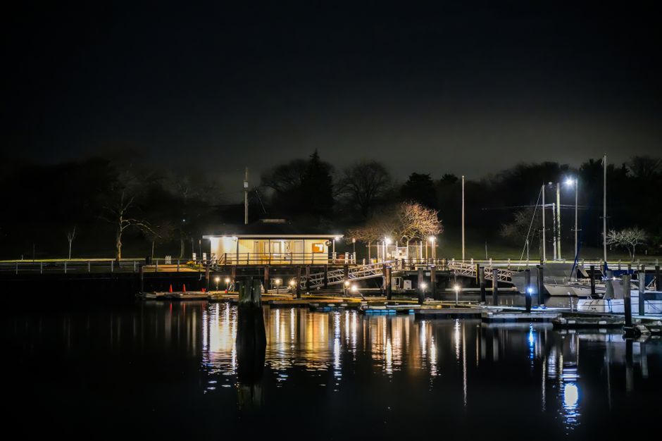 Fire crews responding to a boat fire at a coastal marina at night