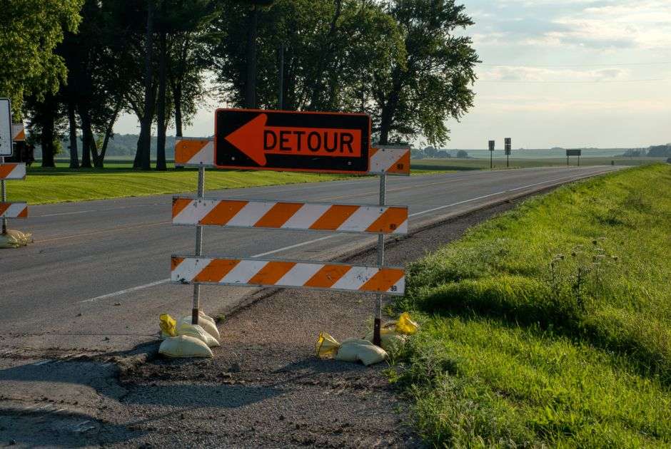 A detour sign directs traffic away from a roadway construction area