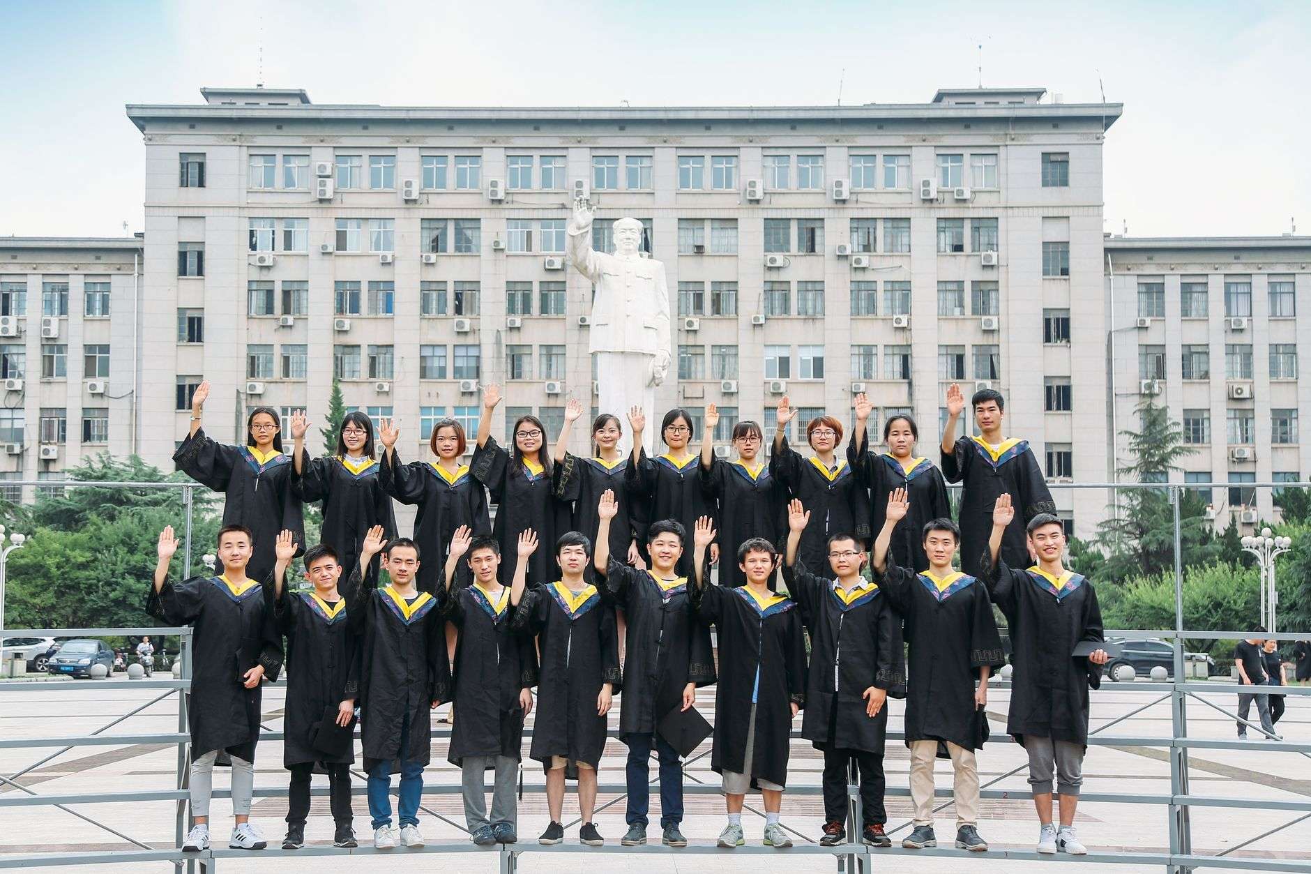 Group of university graduates in caps and gowns posing outdoors