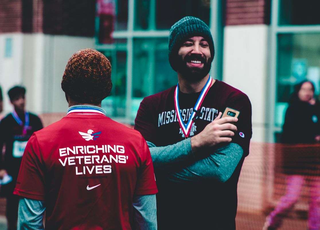 A volunteer shares a light moment with a veteran at a community event