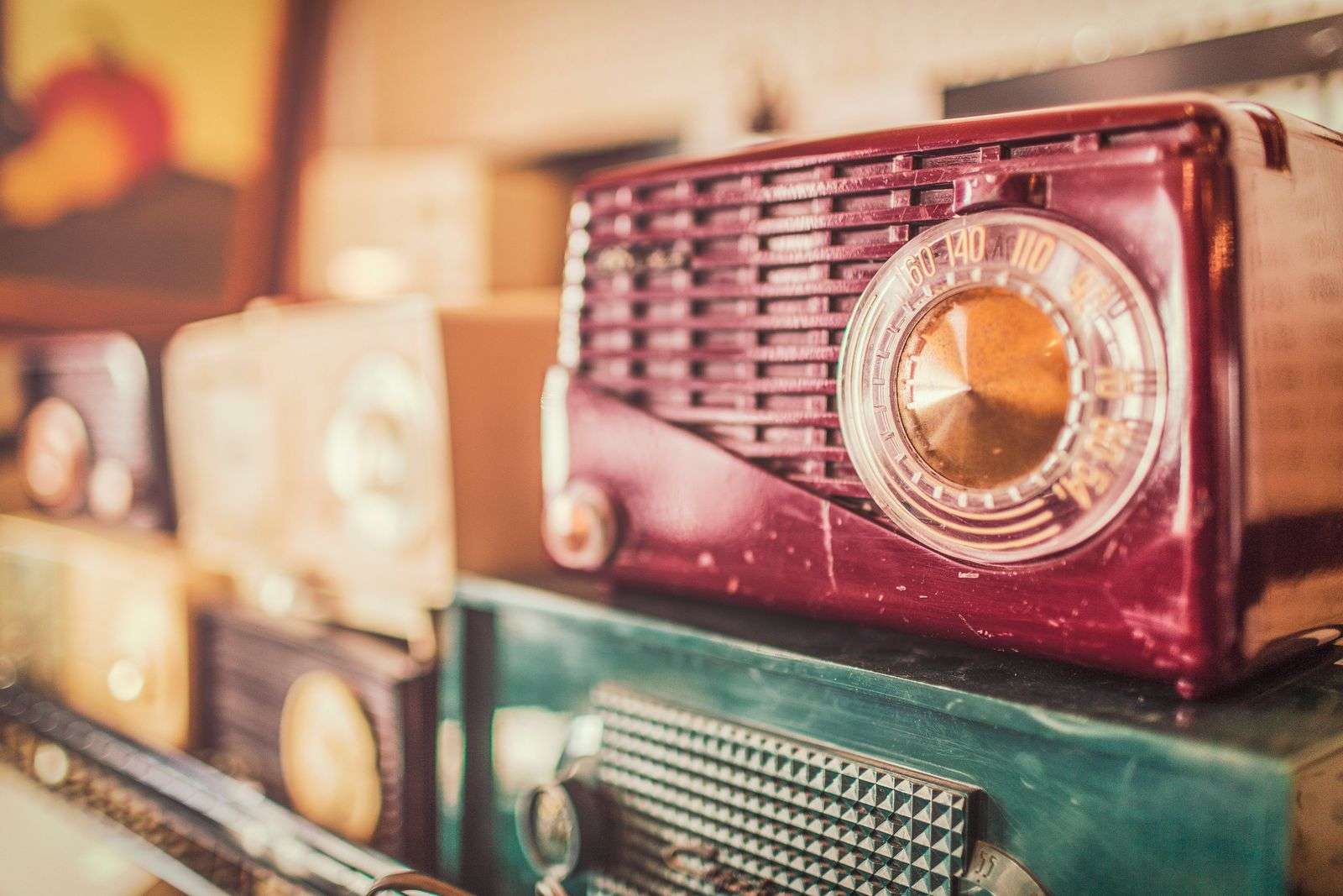 A collection of vintage radios reminiscent of the sets used to hear early Mobile radio broadcasts