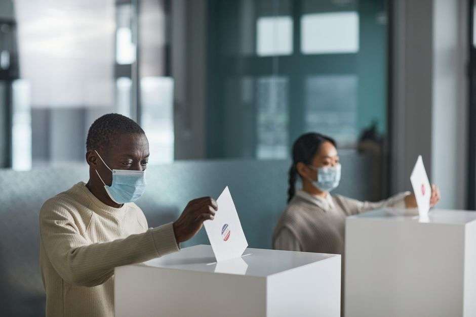 Voters wearing face masks cast ballots at a polling place during Alabama's 2020 election season