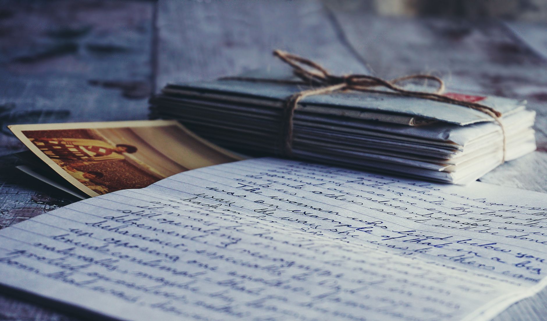Old handwritten letters and vintage photographs arranged on a table