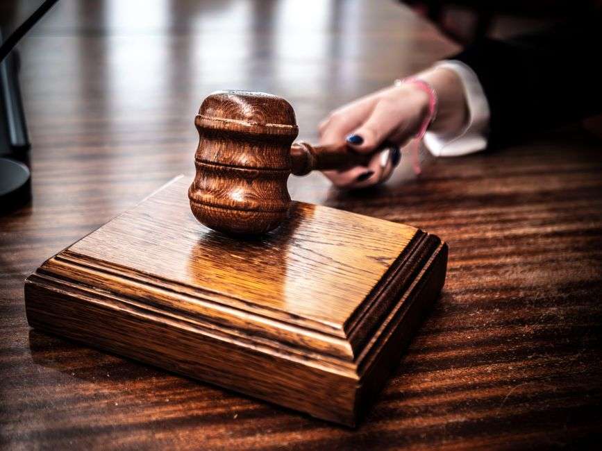 Close-up of a wooden gavel resting on a judge's desk