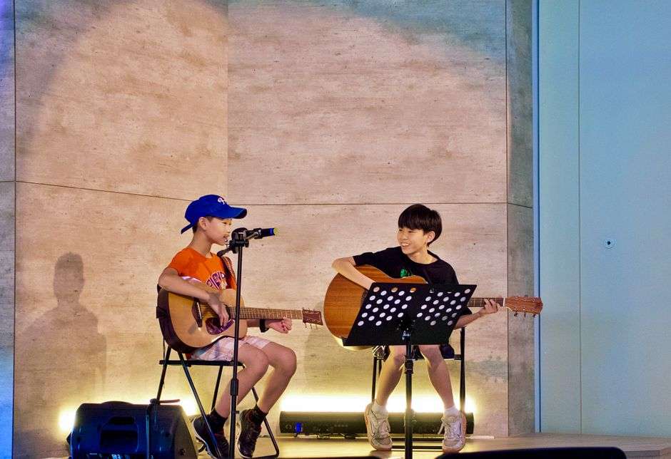 Young musicians perform on stage during a community concert