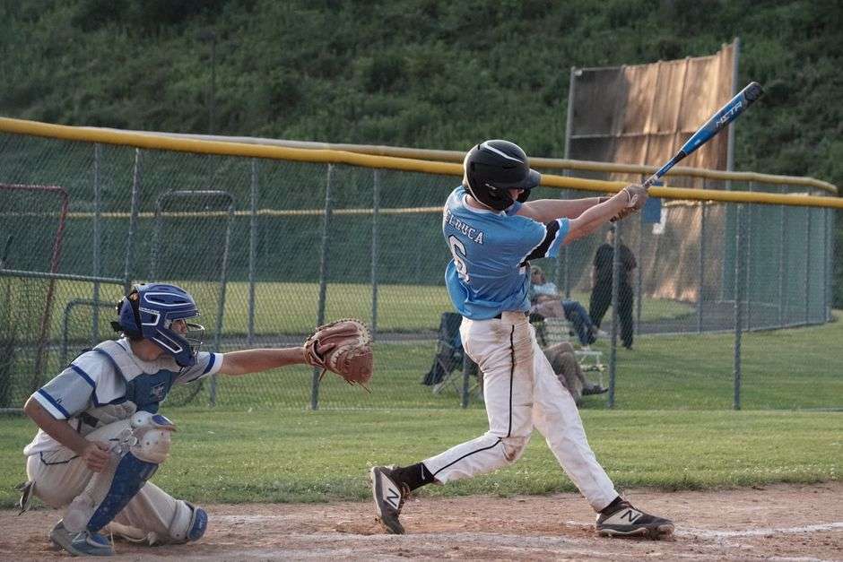 A young baseball player swings at a pitch during a youth tournament game