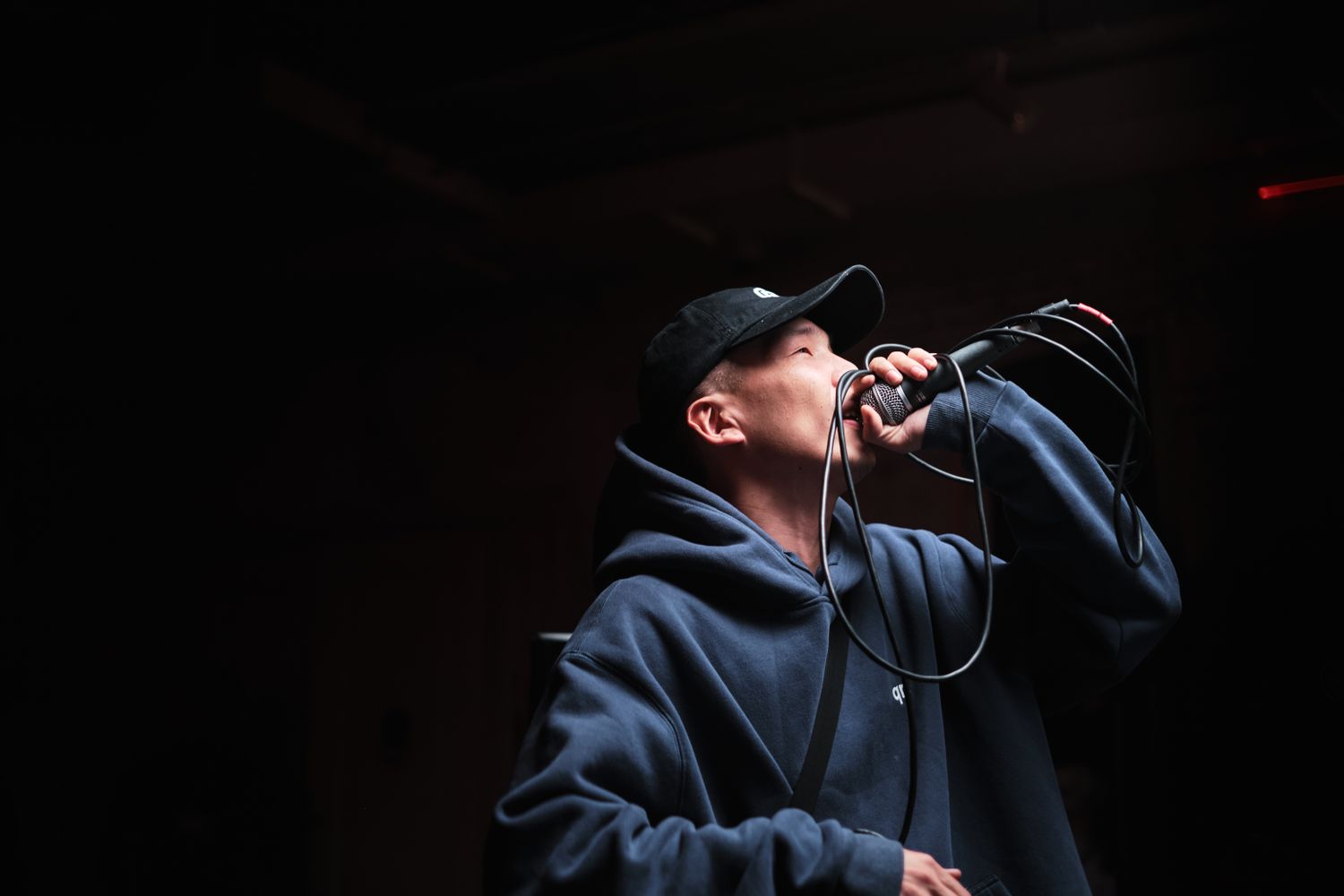 Hip hop performer on stage with a microphone under stage lights
