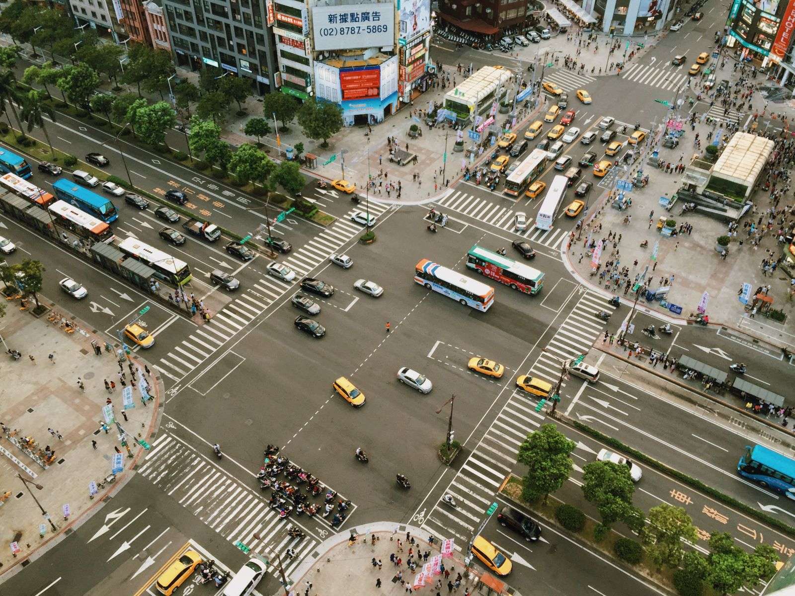 Overhead view of cars passing through a busy urban intersection