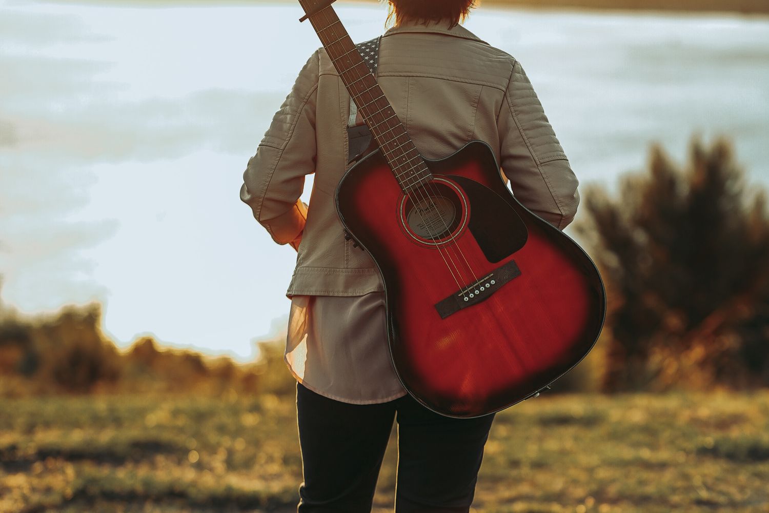 Musician playing an acoustic guitar in an outdoor beach setting