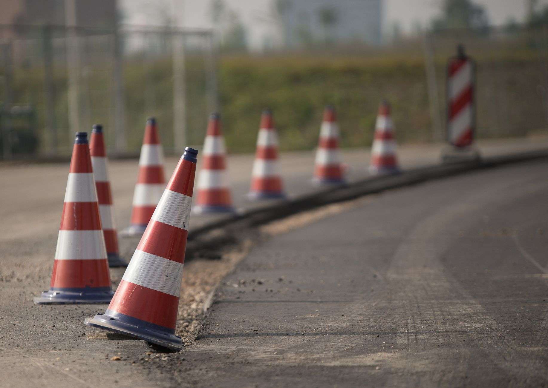 Road construction work zone with equipment and traffic cones on a highway