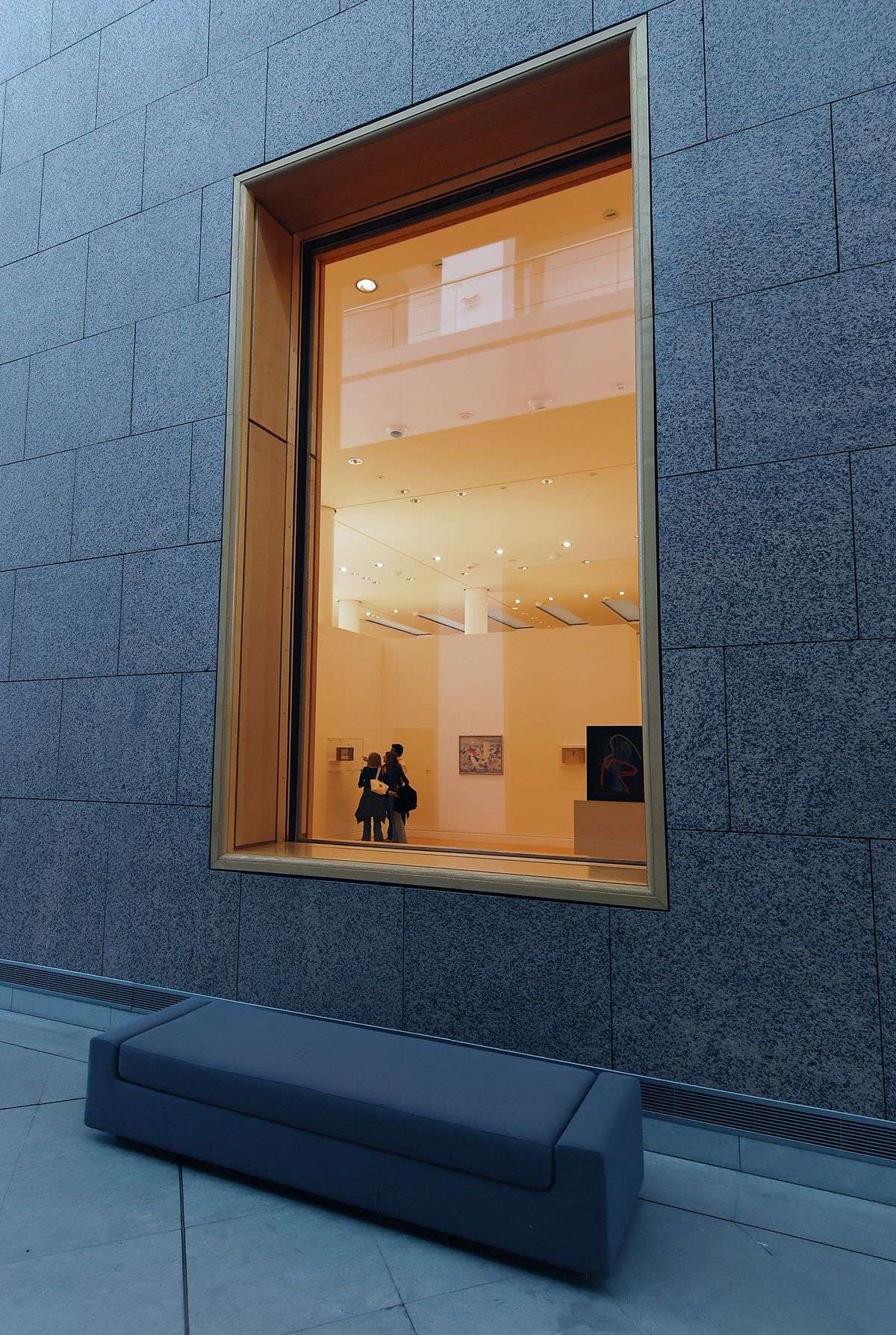 Visitors viewing photographs displayed on gallery walls during an art exhibition