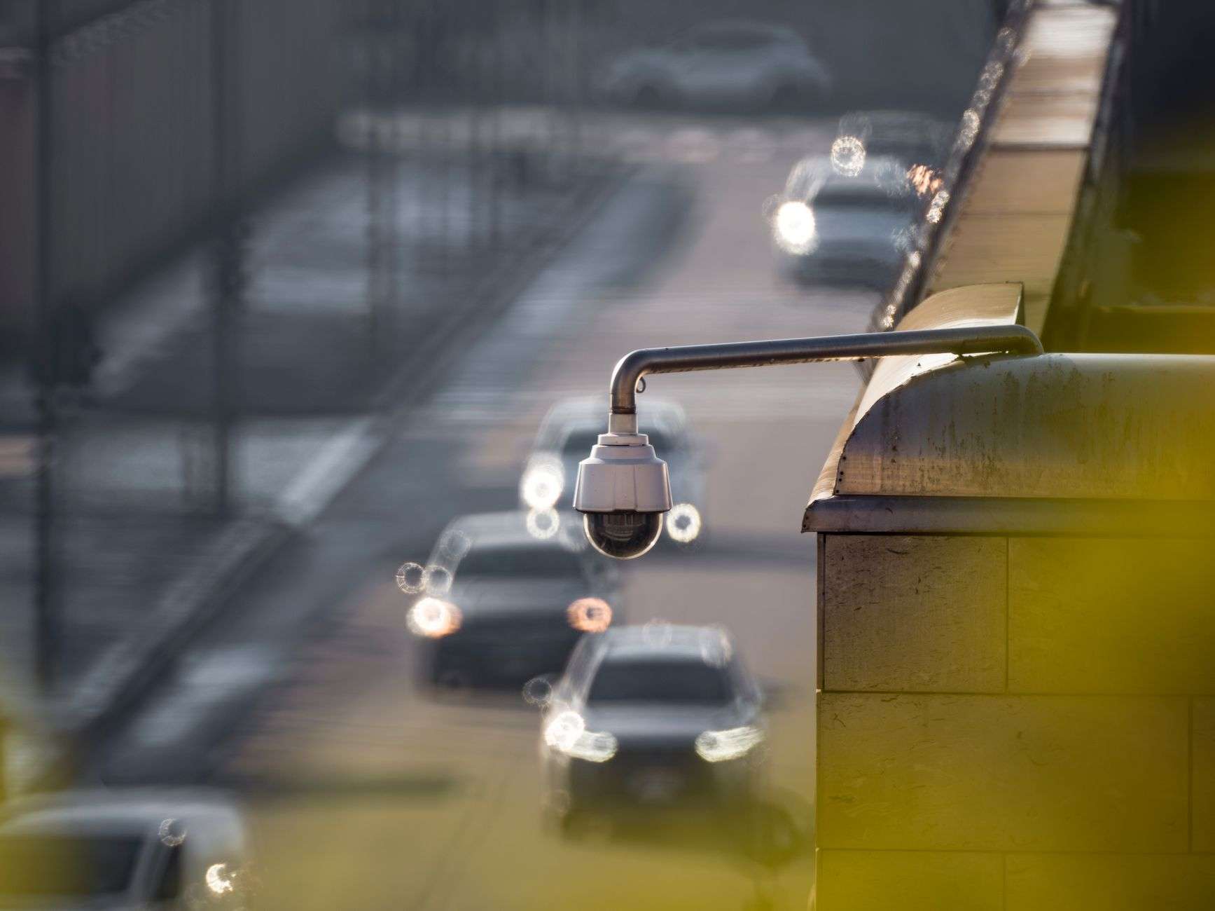 A traffic surveillance camera mounted on a pole above a roadway