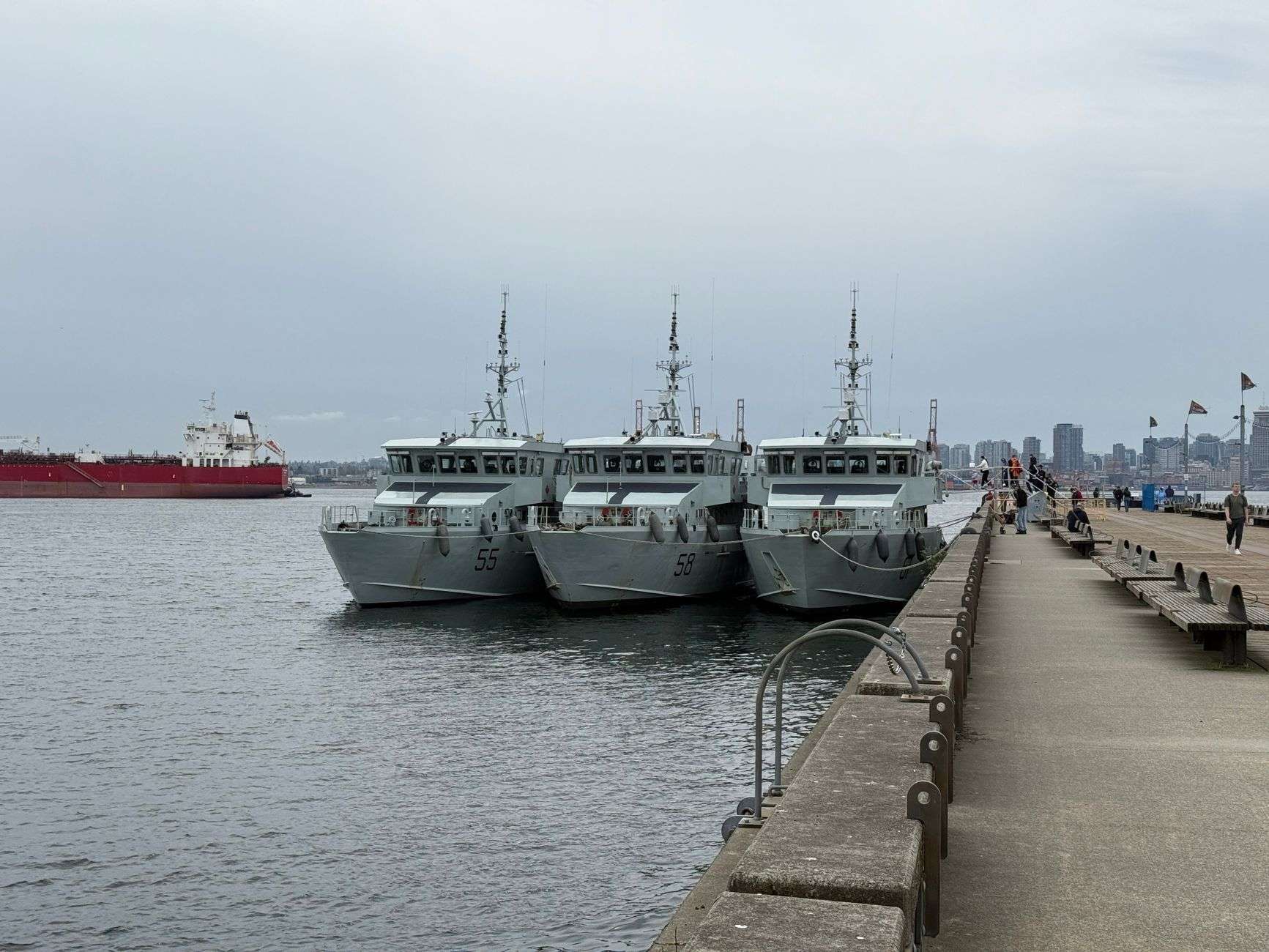 A gray military landing craft vessel docked at a shipyard