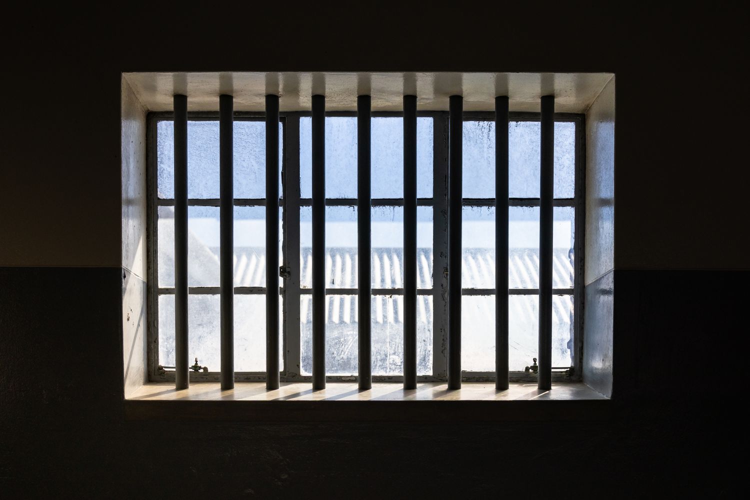 Metal bars of a jail cell inside a correctional facility