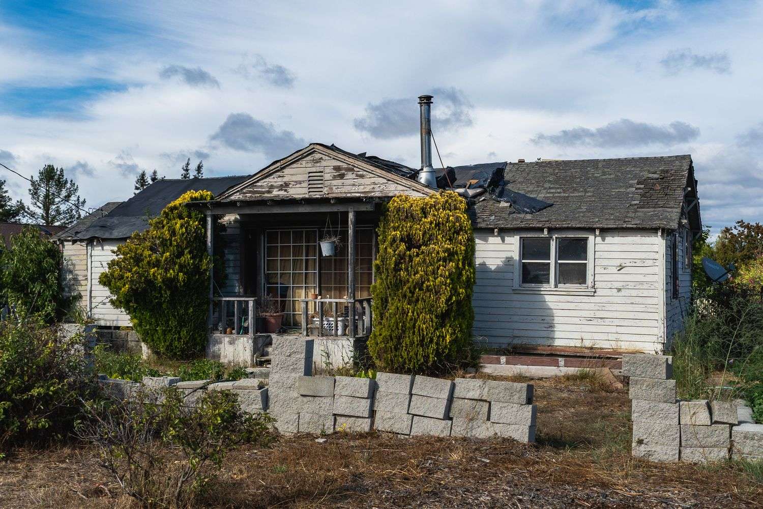 An abandoned house with plywood covering its windows