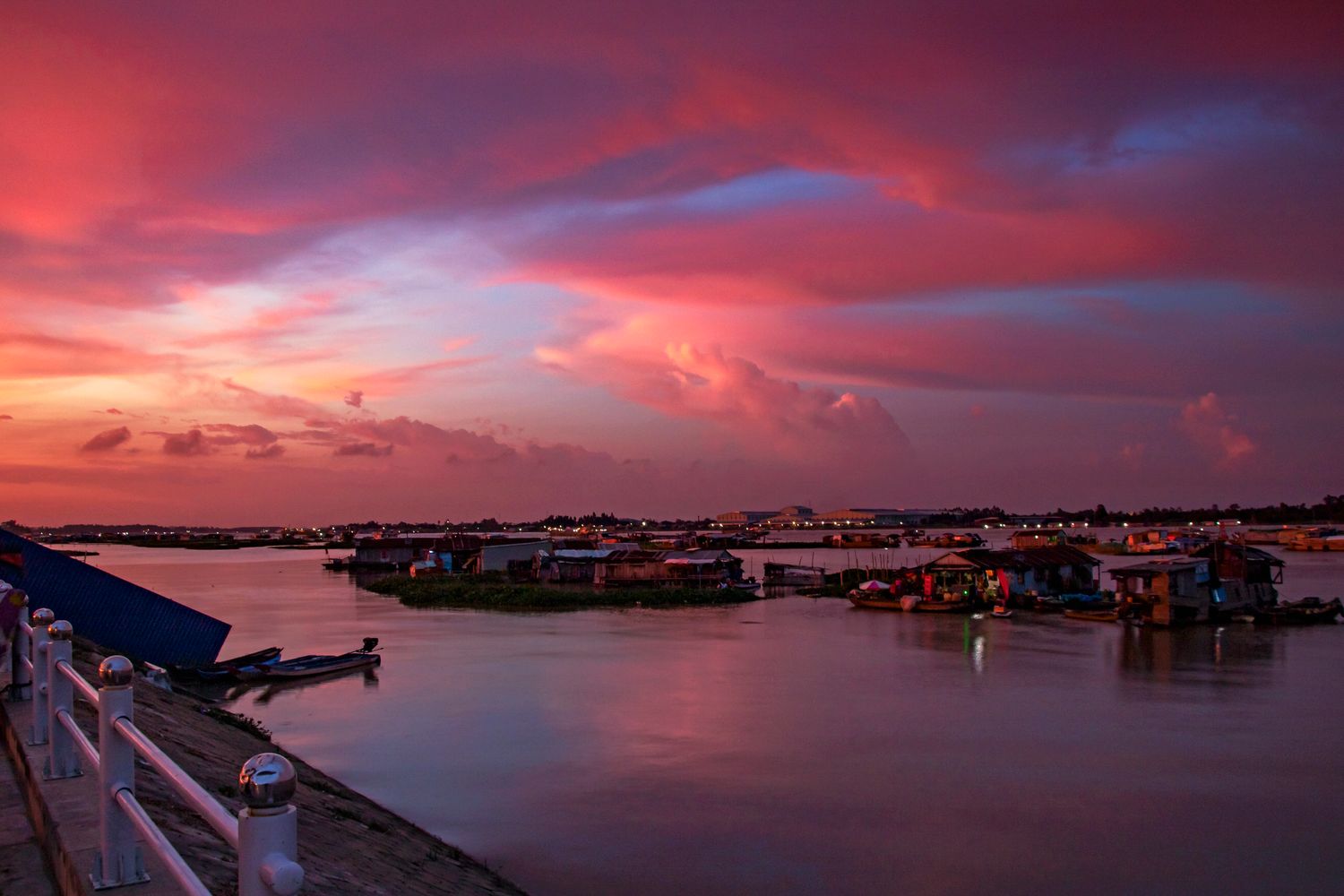 A boat on a wide river delta at sunset