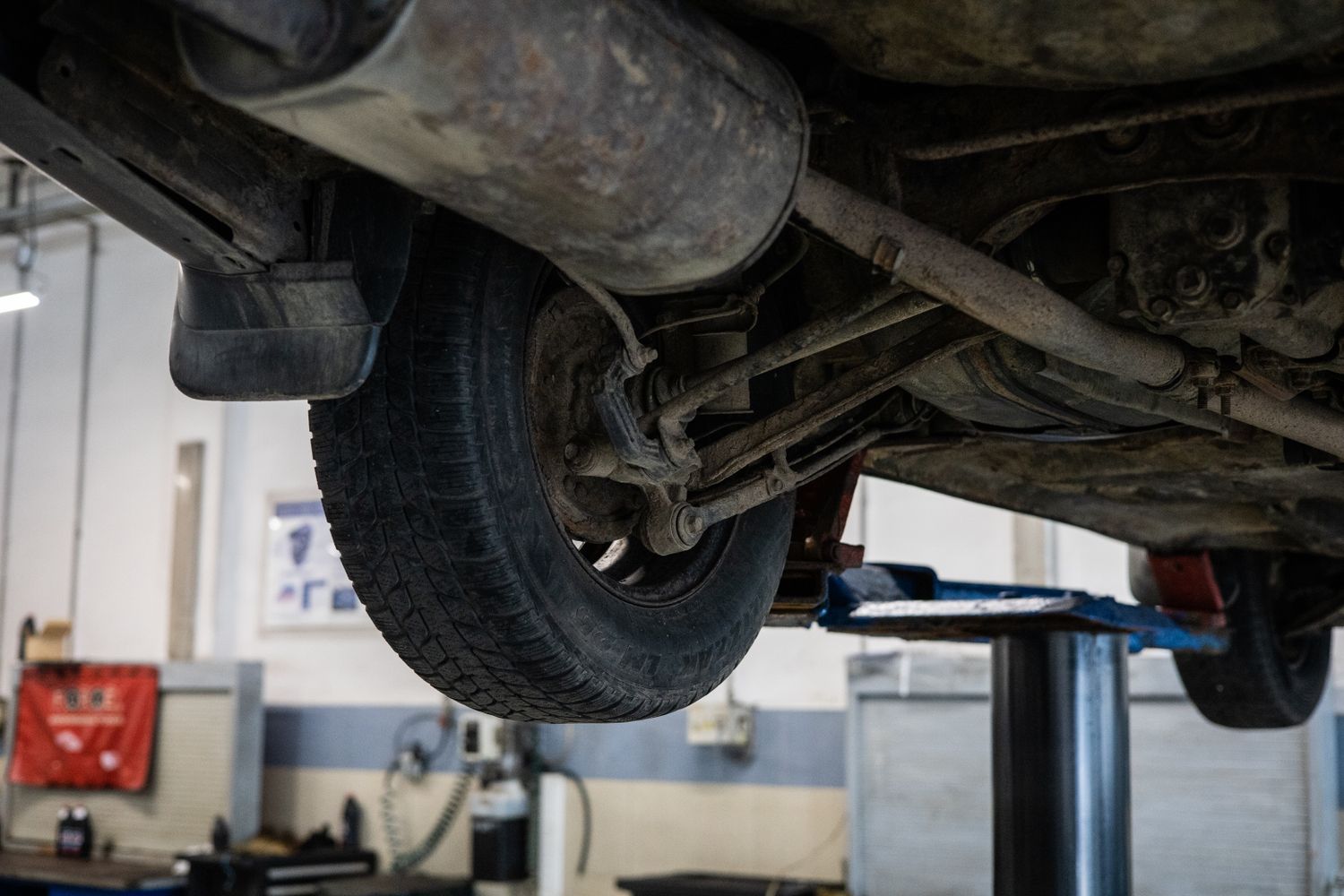 A vehicle raised on a lift showing the exhaust system where catalytic converters are mounted