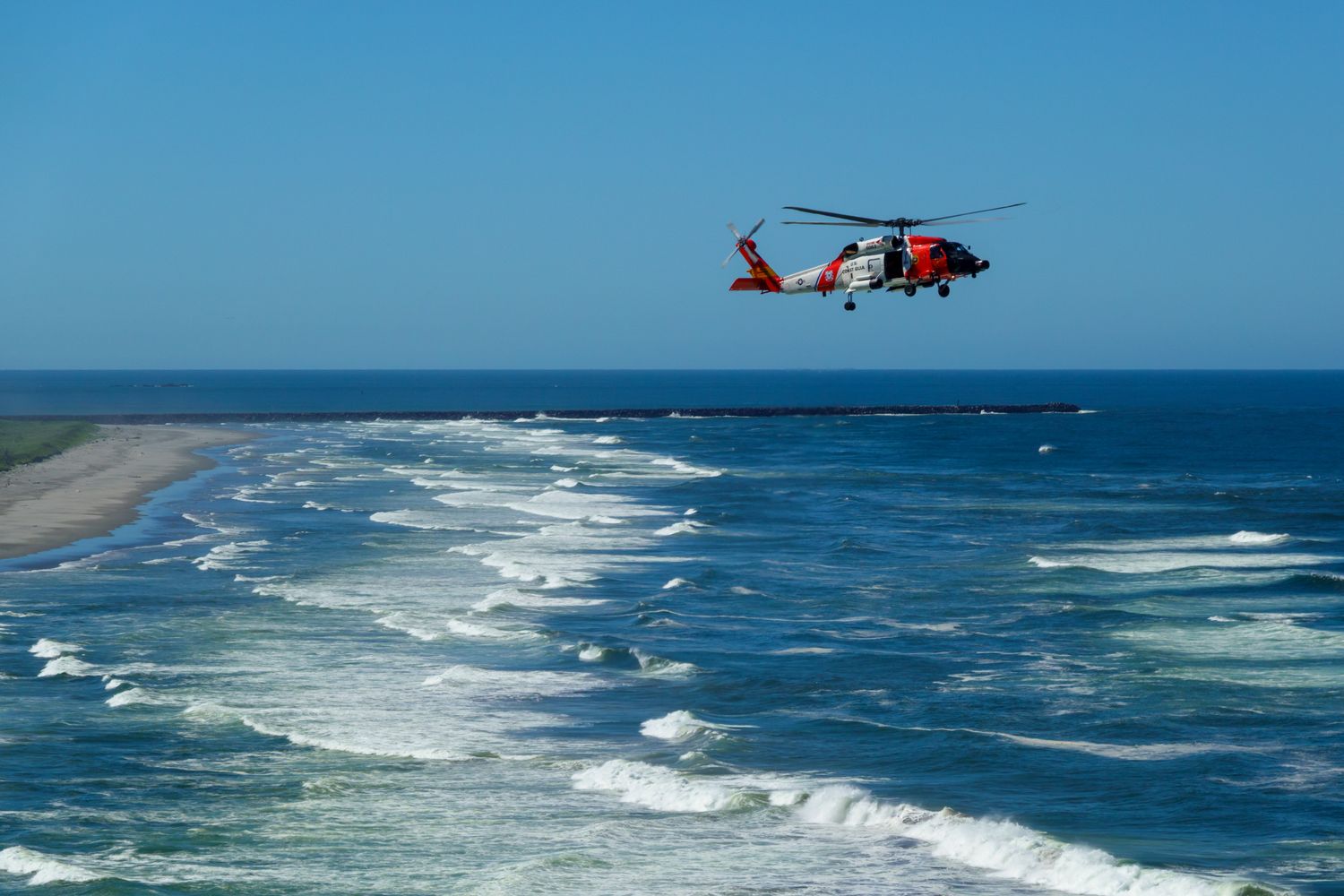 Coast Guard MH-65 Dolphin helicopter scanning open water for a missing person