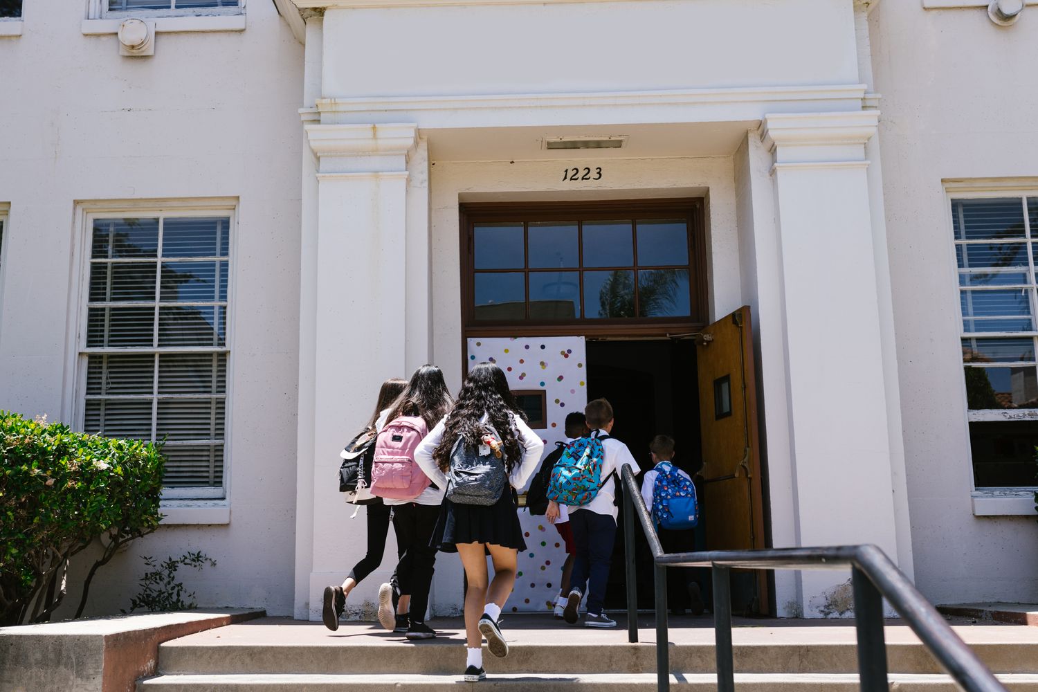 Students walking into a school building on the first day of class