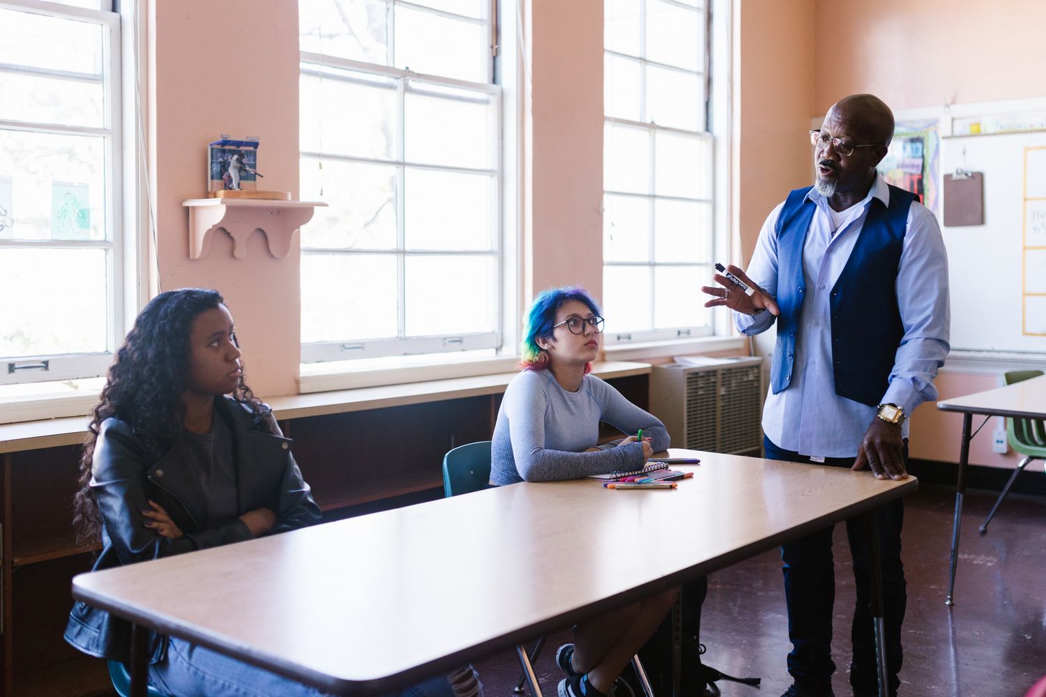 A teacher helping students in a skilled trades workshop classroom