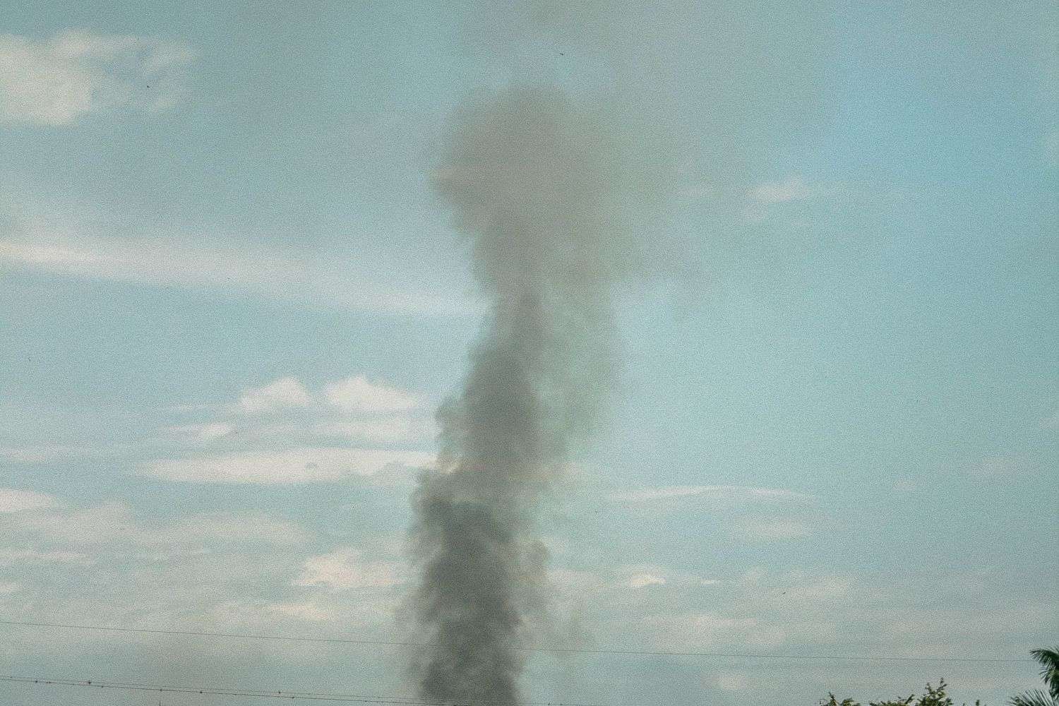 A large plume of dark smoke rising from a fire
